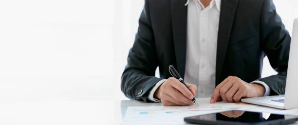 istock young man in suit working with document at desk in modern office, doing planning analyzing the financial report, business plan investment, finance analysis concept. copy space. 1362177551