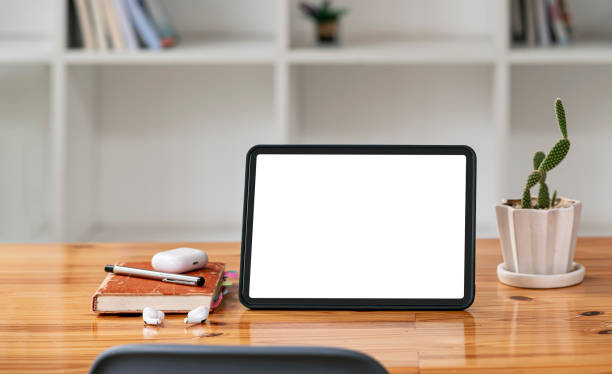 istock Blank screen portable tablet on wooden table in modern workspace and office room. Mockup blank screen for product display. 1362177570