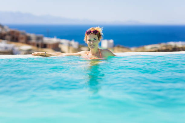 istock Woman enjoying view from endless swimming pool 1362180800