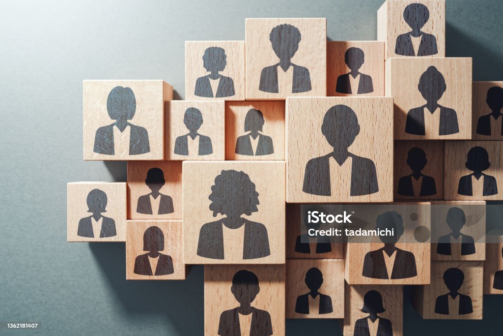Team work and human resource management concept. Top view of various wood cubes with people icons. Human Resources Stock Photo