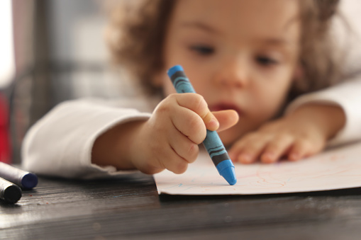 Little girl painting with colorful pencil