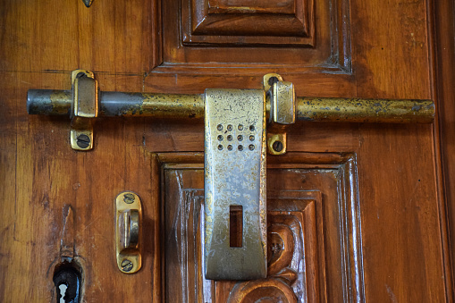 Stock photo of antique Indian style bronze metal door lock on wooden door, Picture captured at Bangalore Karnataka, India. selective focus.