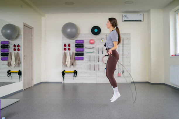 istock Young attractive woman using jump rope while training in the gym 1362192684
