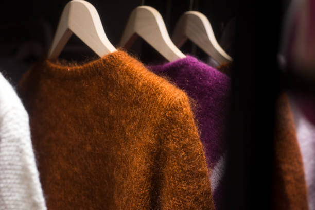 colorful woolen pullover on hangers in a woman fashion store showroom stock photo