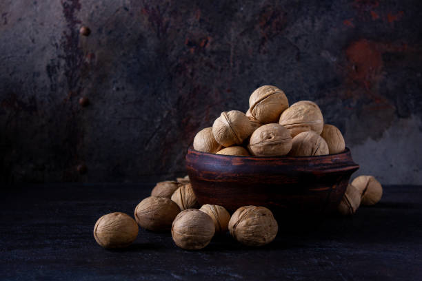 istock bowl with walnuts on a dark background, place for text 1362196034