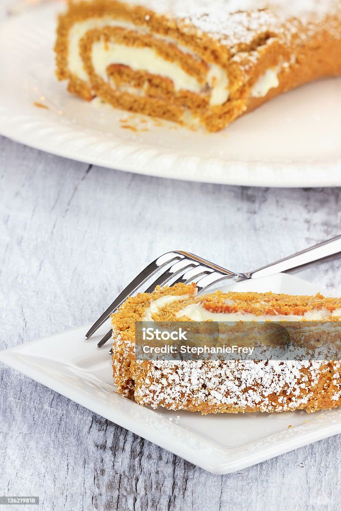 Holiday Pumpkin Roll Slice of pumpkin roll with more in background. Baked Stock Photo