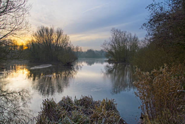 istock Winter sunrise over a misty lake 1362202285
