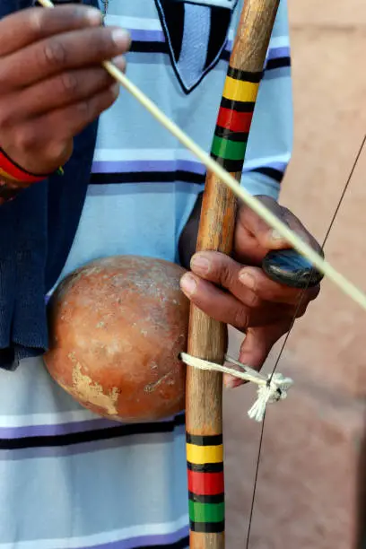 Photo of Closeup of hands of man playing berimbau