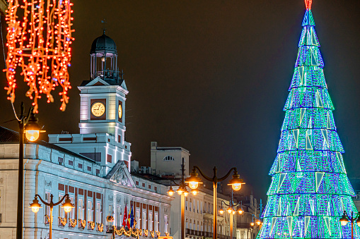 Navidad en la Puerta del Sol, en la ciudad de Madrid con iluminación y decoración típica, el reloj y el árbol de navidad photo