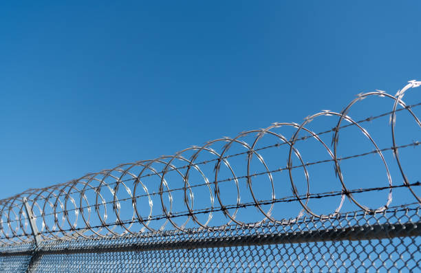 barbwire perimeter fence. ensuring safety and security. jail wall.