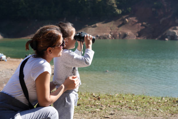 istock Mother and daughter playing with binoculars in the woods. 1362216551