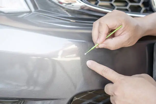 Close up hand a man holding together for preliminary car paint repair from an accident : basic car service that can be made by yourself