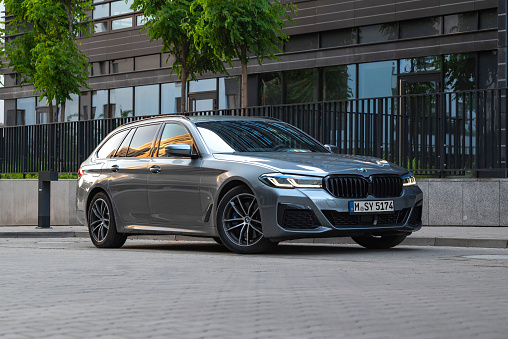 Berlin, Germany - 13 June, 2021: BMW 5-series Touring PHEV parked on a street. The 5-series model is one of the most popular car in premium segment.