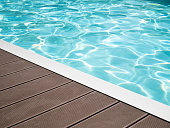 Tropical floor swimming pool modern with clean water, outdoor swimming pool edge wooden pavement