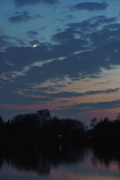 istock crescent moon after sunset on a colorful evening sky over trees on lake shore 1362219351