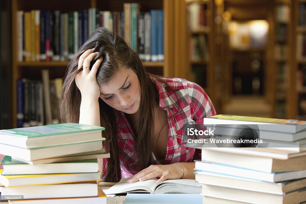 Concentra estudiantes rodeado de libros - Foto de stock de Estrés libre de derechos