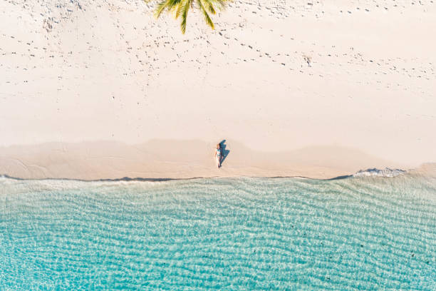 istock Woman lying back on white sand beach 1362220318