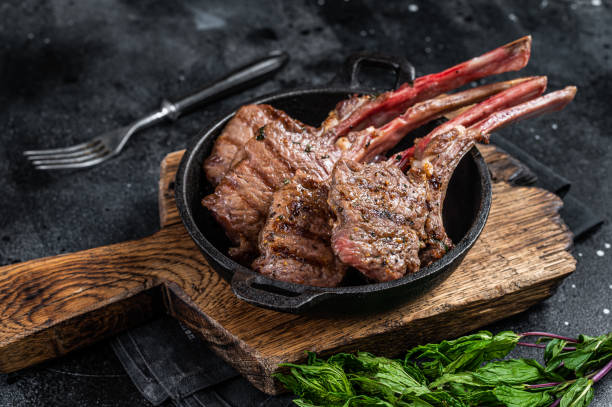 istock BBq Grilled lamb mutton chops steaks in a pan. Black background. Top view 1362220941