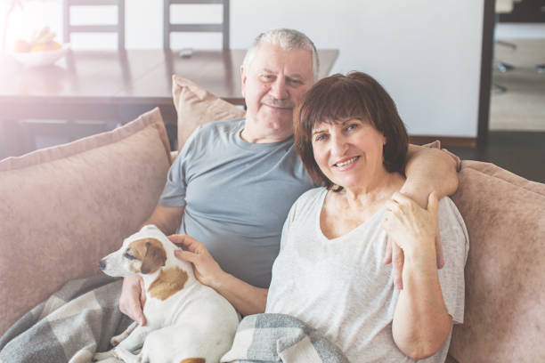istock Happy elderly couple sitting on sofa at home 1362222392