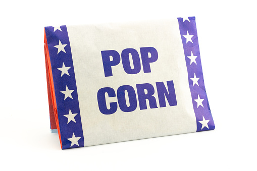 White and blue paper packaging popcorn with corn kernels for microwave isolated on white background