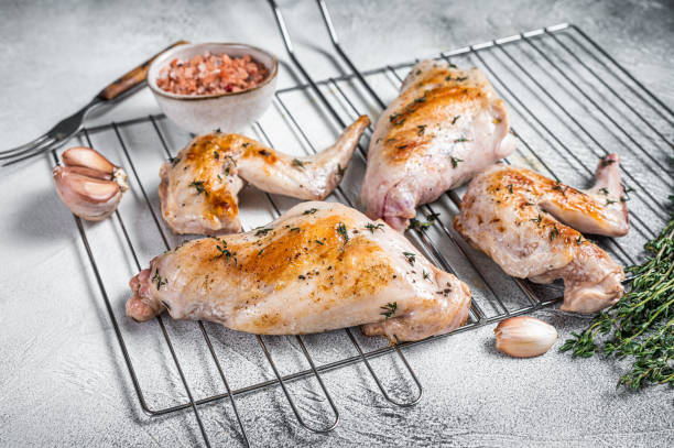istock Baked rabbit legs on a grill with thyme. White background. Top view 1362222526