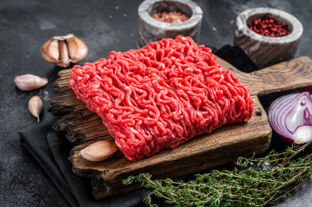 istock Raw Mince, minced Ground beef meat on a cutting board. Black background. Top view 1362222800