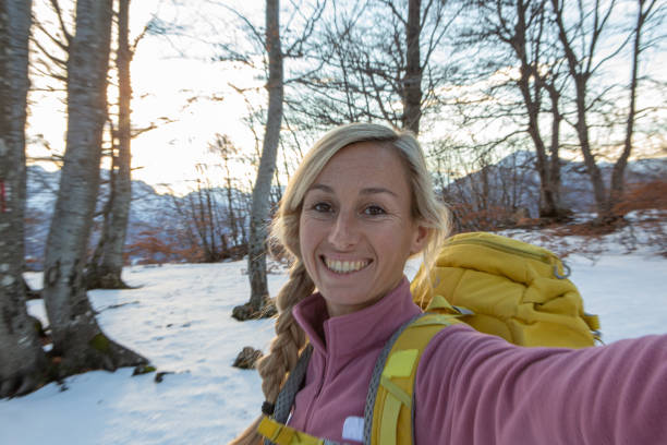 Young woman taking selfies in the forest during a winter hike Young woman taking selfies in the forest during a winter hike publicity event stock pictures, royalty-free photos & images