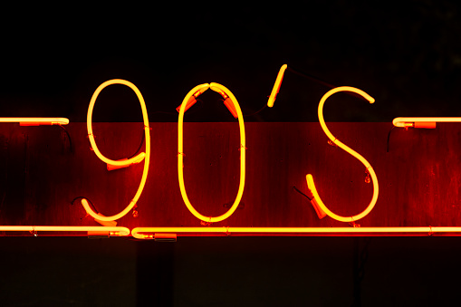 Red neon light above a restaurant saying 90's.