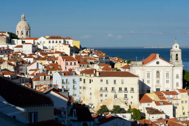 Panoramic view of the Alfama historic neighborhood of Lisbon and the Santo Estevao church at sunset from Portas do Sol viewpoint. Portugal. Lisbon, Portugal - September 02, 2021: Panoramic view of the Alfama historic neighborhood of Lisbon and the Santo Estevao church at sunset from Portas do Sol viewpoint. Portugal. cirque de soleil stock pictures, royalty-free photos & images
