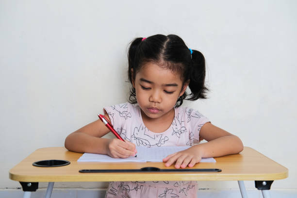 istock Asian little girl showing serious expression during study 1362228692