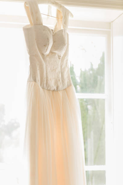 istock Wedding dress hung in window light 1362230571