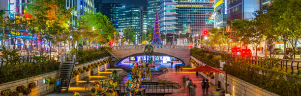córrego seul cheonggyecheon iluminado à noite entre arranha-céus panorama coreia - built structure building exterior asian culture seoul - fotografias e filmes do acervo