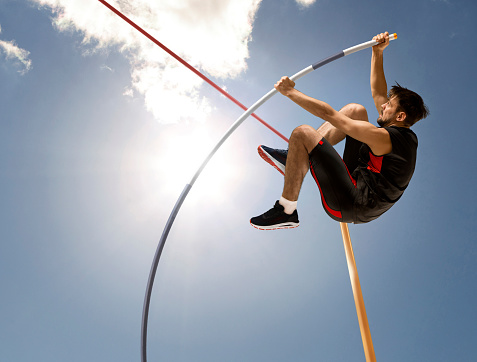 Professional pole vaulter training at the stadium. Copy space background