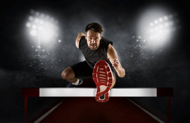 istock Man athlete hurdler running jumping over hurdles 1362233080