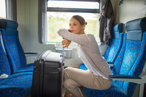 istock Pretty young woman aboard a train, going for her vacation destination 1362239036