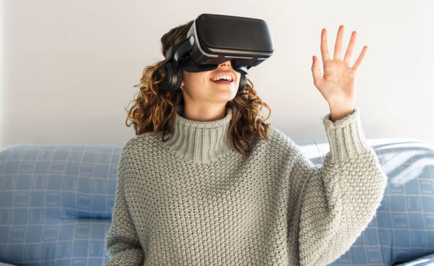 woman using vr glasses at home - realidade virtual imagens e fotografias de stock