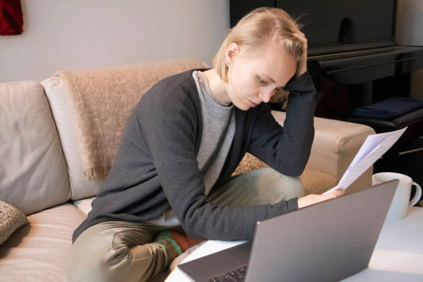 istock Worried woman looking at document 1362249744