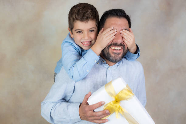 istock Funny boy giving a gift to his father 1362251246