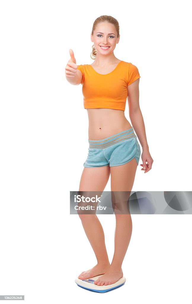 Young woman on scales Young woman on scales isolated Achievement Stock Photo