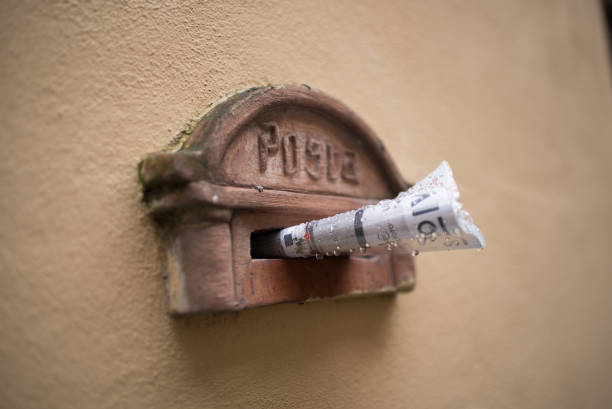 istock Brown mailbox (Posta) with newspaper in plastic packaging in front of a yellow-brown wall 1362255389