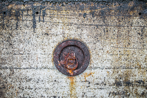 Rusty circular object on a grungy background.