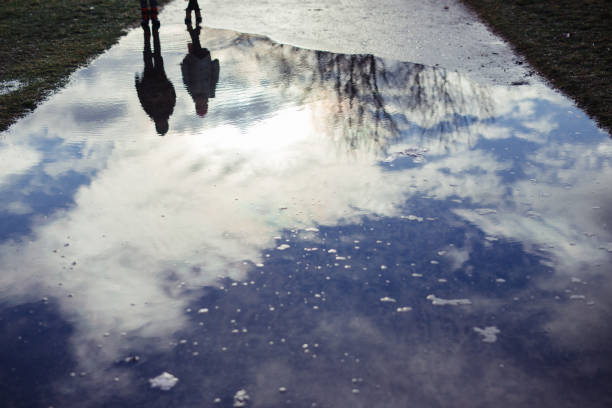 istock Puddle. Reflections of the sun and clouds 1362256016
