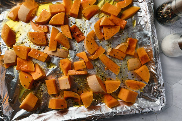 istock Raw butternut squash cut into pieces, on an oven tray covered with aluminum foil. 1362258196
