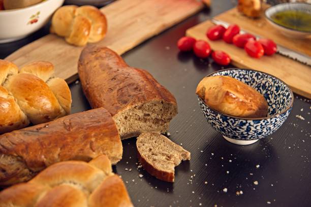 istock Feast, messy table. Bread in the shape of a braid. Sweet Challah. breakfast, side view. Cherry tomatoes and olive oil, Balsamic vinegar, Atlantic salt 1362259383