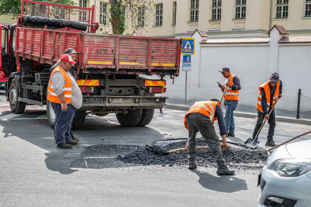 Workers repair broken asphalt road stock photo