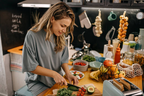 istock Women cutting avocado in modern kitchen 1362263354