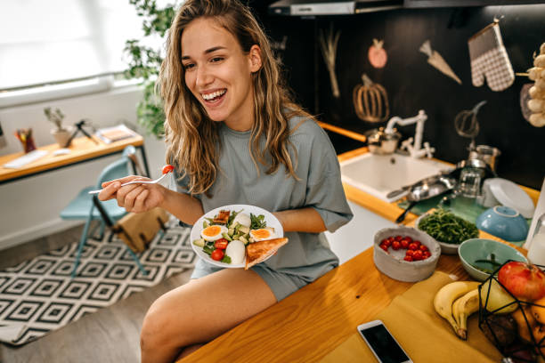 женщины едят здоровый завтрак дома - morning tomato lettuce vegetable стоковые фото и изображения