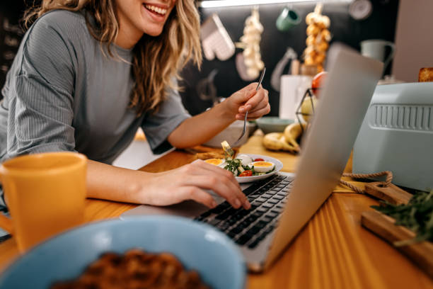 istock Woman using laptop and eating breakfast 1362263570