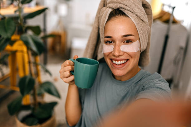 mujer con parche en el ojo tomando selfie - tea women beauty pampering fotografías e imágenes de stock