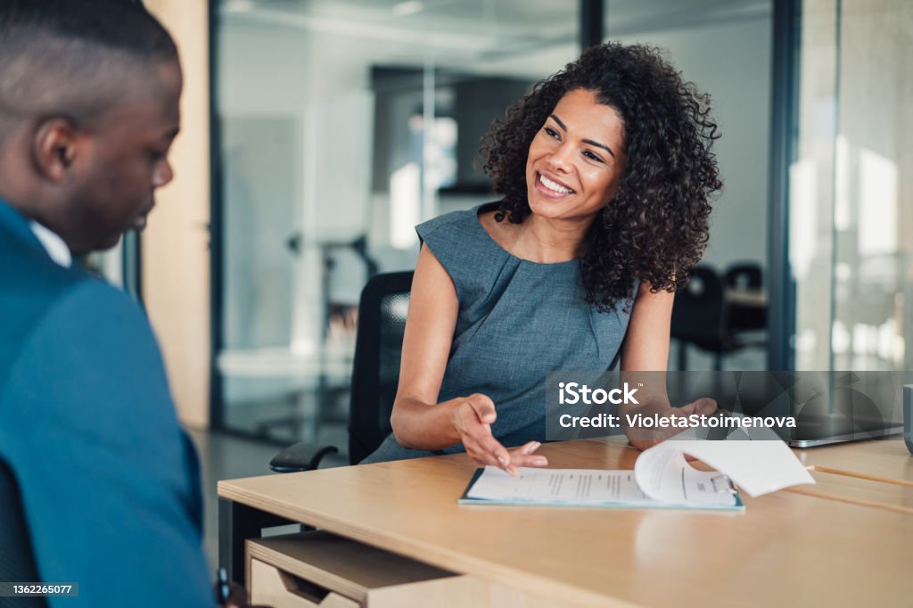 Business people signing a contract. Shot of two business persons filling in paperwork in the office. Businessman and businesswoman signing a document in board room. Human Resources Stock Photo